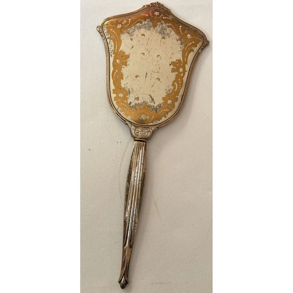 Vintage or antique gold-tone handheld vanity mirror.